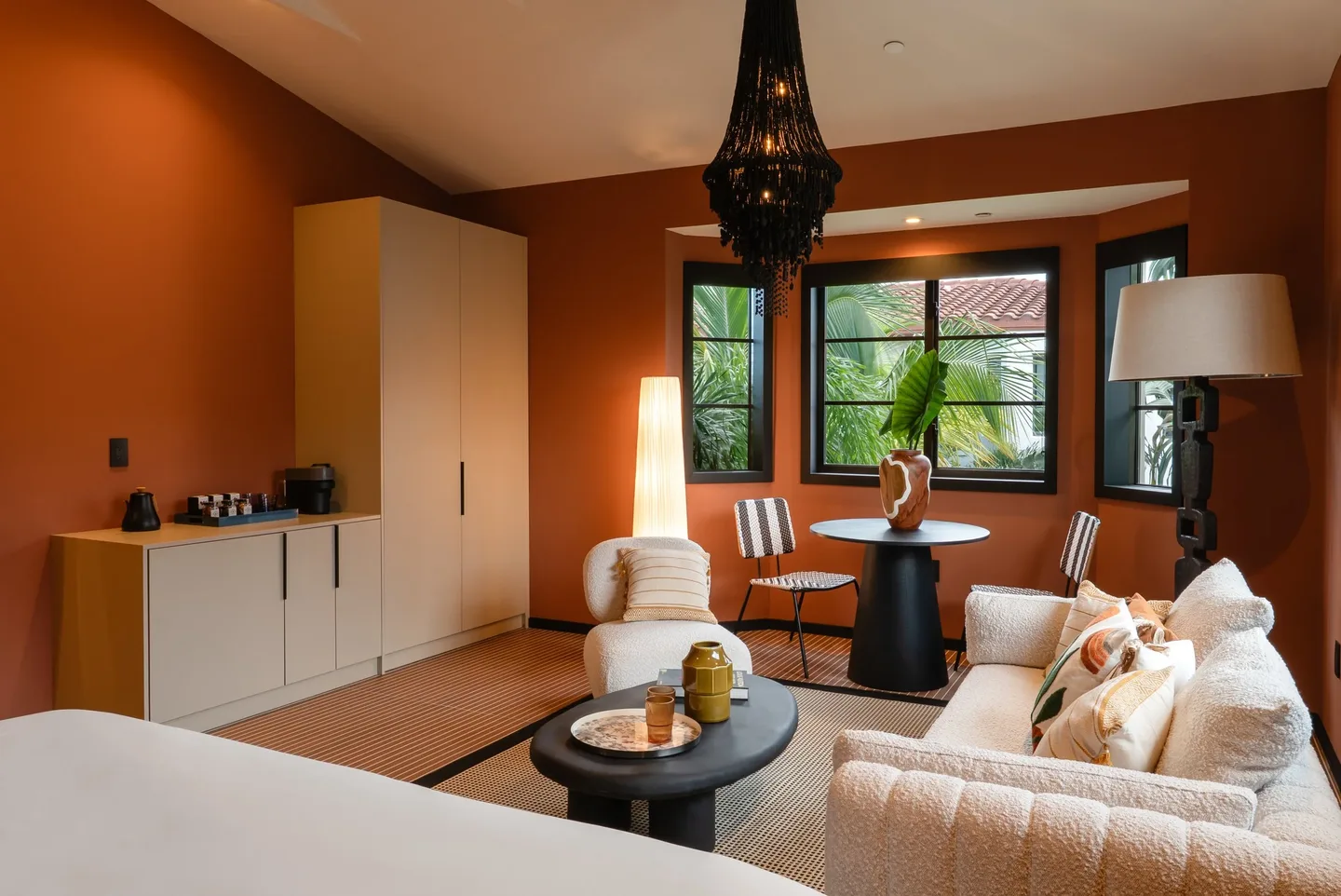 A living room with orange walls, a white couch, and a black table.